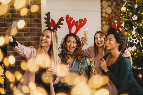 Multiracial Group Of Female Friends Taking Selfie Near The Christmas Tree During Celebrating Holidays
