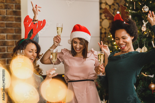 Multiracial Female Friends Having Fun And Dancing At Home Christmas Party
