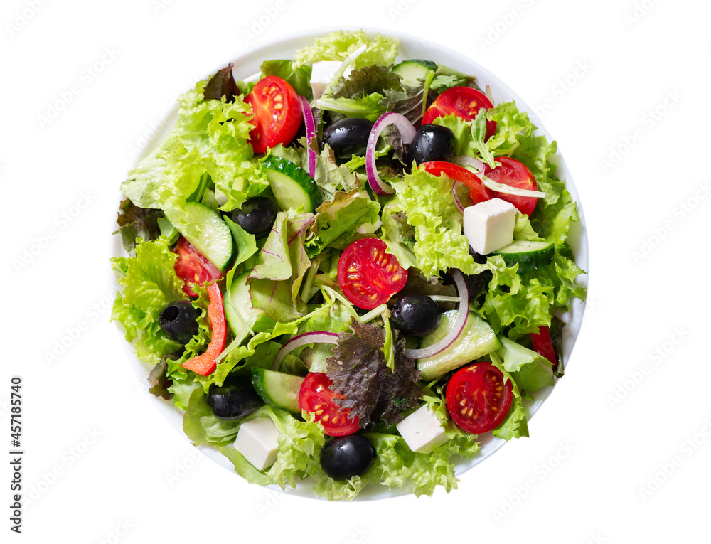 Plate of fresh salad with vegetables, feta cheese and olives isolated on white background