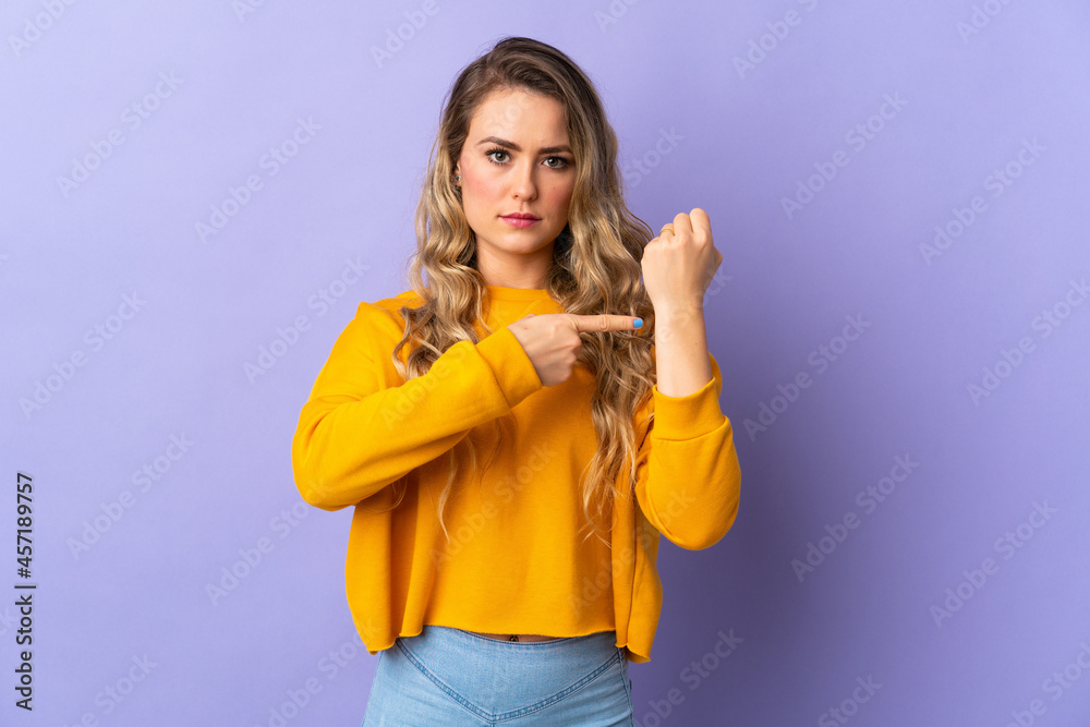 Young Brazilian woman isolated on purple background making the gesture of being late Young Brazilian woman isolated on purple background making the gesture of being late