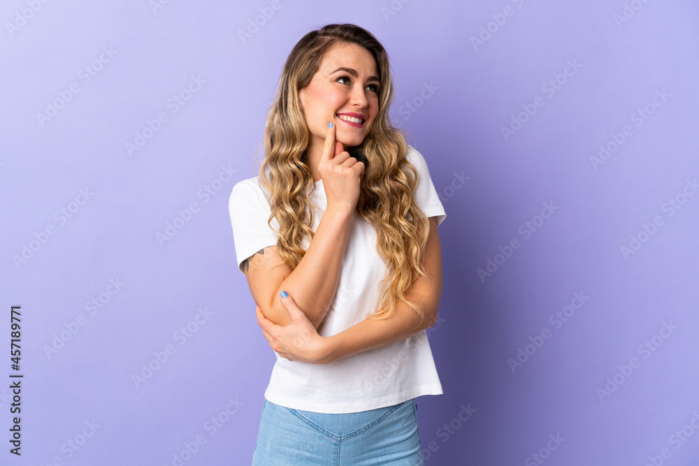 Young Brazilian woman isolated on purple background thinking an idea while looking up Young Brazilian woman isolated on purple background thinking an idea while looking up