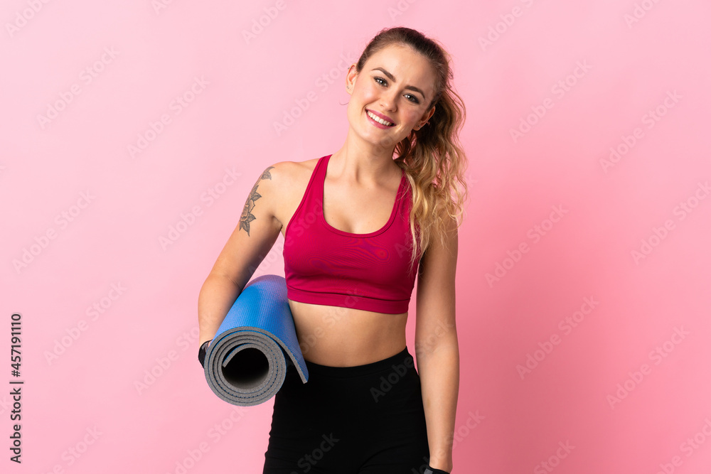 Young Brazilian woman isolated on pink background with a mat and smiling Young Brazilian woman isolated on pink background with a mat and smiling