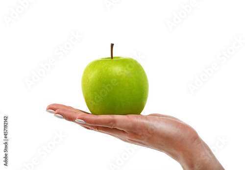 Woman hand holds green apple over white