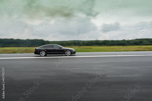 Side view of a high performance luxury car in motion  © West