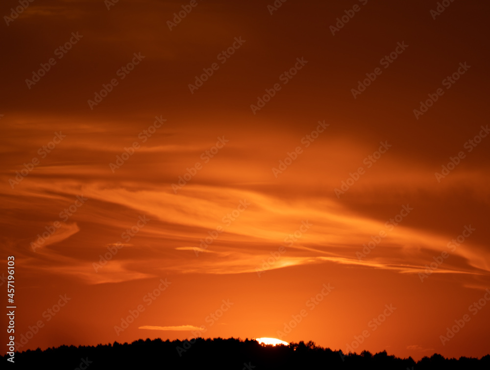 Orange sunset with clouds in flow and mountain range