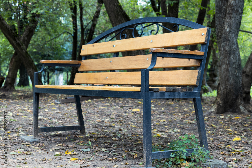 A wooden bench in an autumn park. Close up. A wooden bench in an autumn park. Close up.