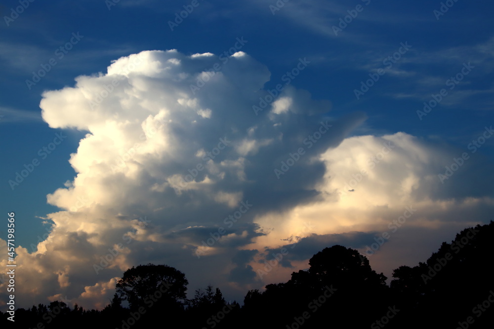 Isolated thunderstorm with blue sky in the distance during sunset