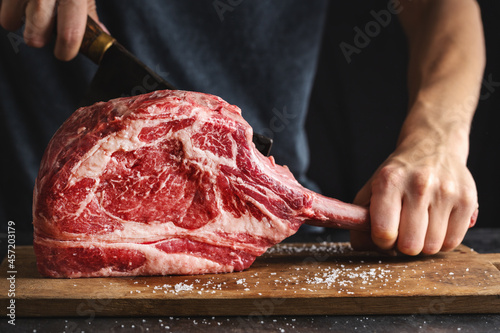 Canvas-taulu Butcher cuting fresh meat tomahawk steak