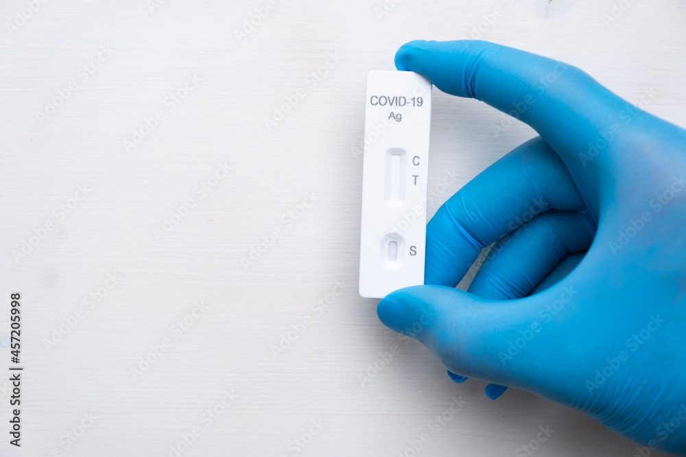 Covid-19 antigenic test for quick detection of disease in doctors hand in the rubber gloves with copy space. Coronavirus test cassette from rapid strep kit. Covid-19 antigenic test for quick detection of disease in doctors hand in the rubber gloves with copy space. Coronavirus test cassette from rapid strep kit.