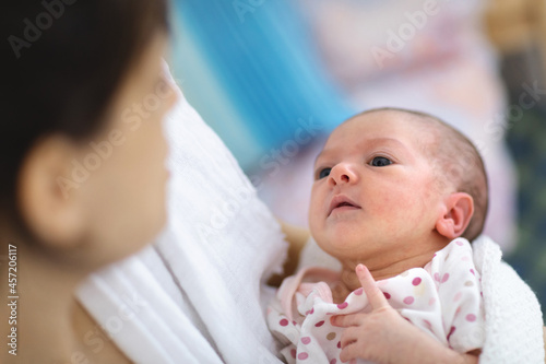 Parent holding cute newborn baby in arms. 