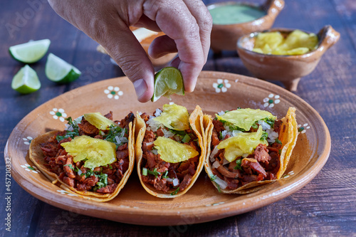 Tacos al pastor  tradicional comida mexicana  con cebolla  cilantro  pi  a  salsa roja o guacamole.