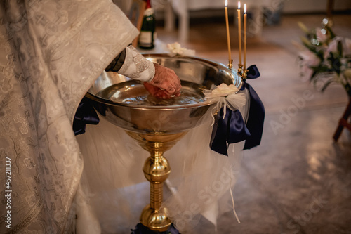 A religious christening event featuring holy water, candles, and ceremonial rituals. photo