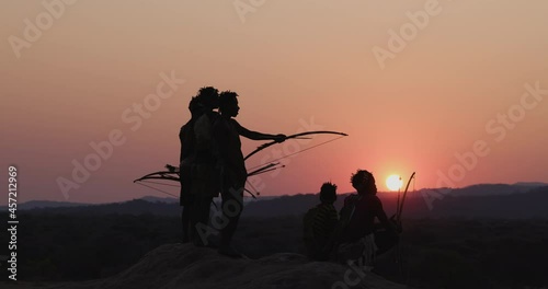 Group of Hadza hunter-gatherer tribesmen out hunting at sunset Tanzania photo