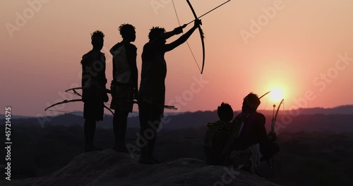 Group of Hadza hunter-gatherer tribesmen out hunting at sunset Tanzania photo