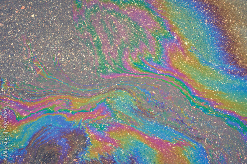 Abstract background from motor oil, gas or petrol spilled on asphalt