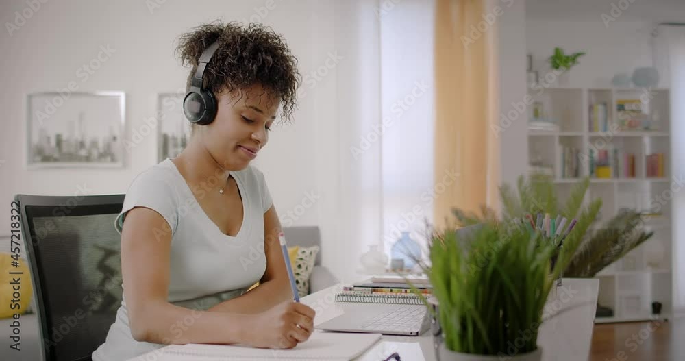 Lateral Dolly of Happy Young African American Woman Working or Studying on Laptop Computer from Home. Video Conference Call at Home Office. Online Learning or Teleworking Concept.