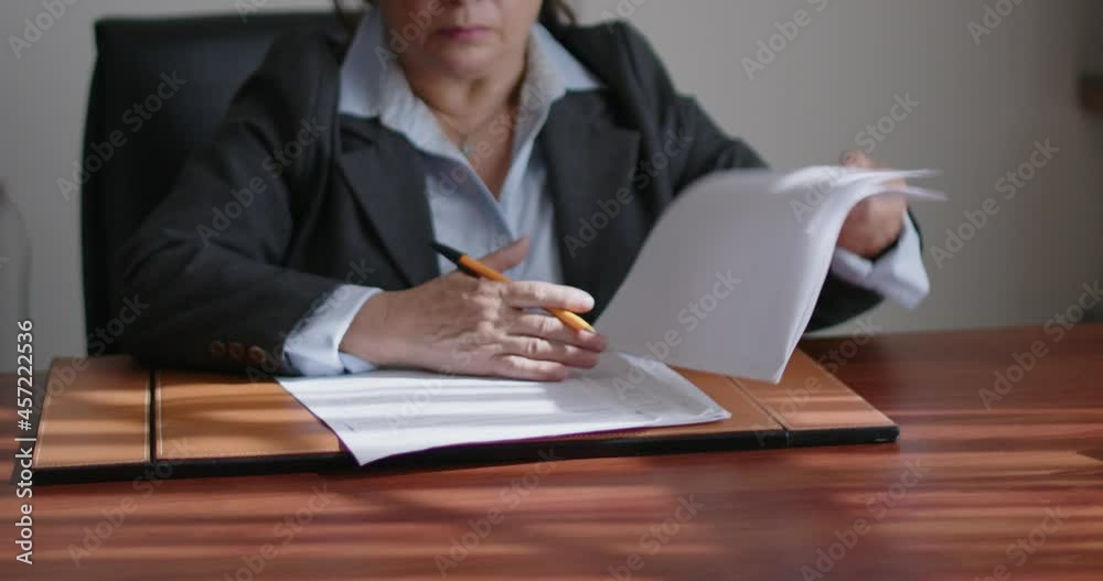 Mujer de negocios de la tercera edad revisando documentos en su oficina.