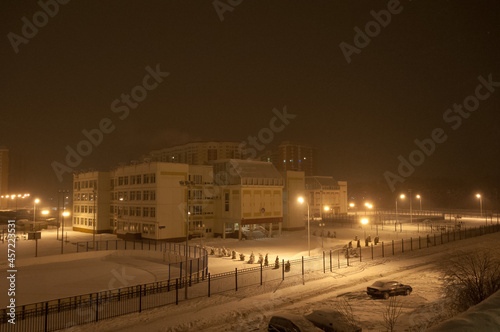 The school building illuminated by street lamps