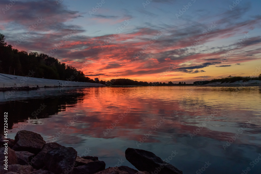 sunset on the river with reflection of sky and clouds