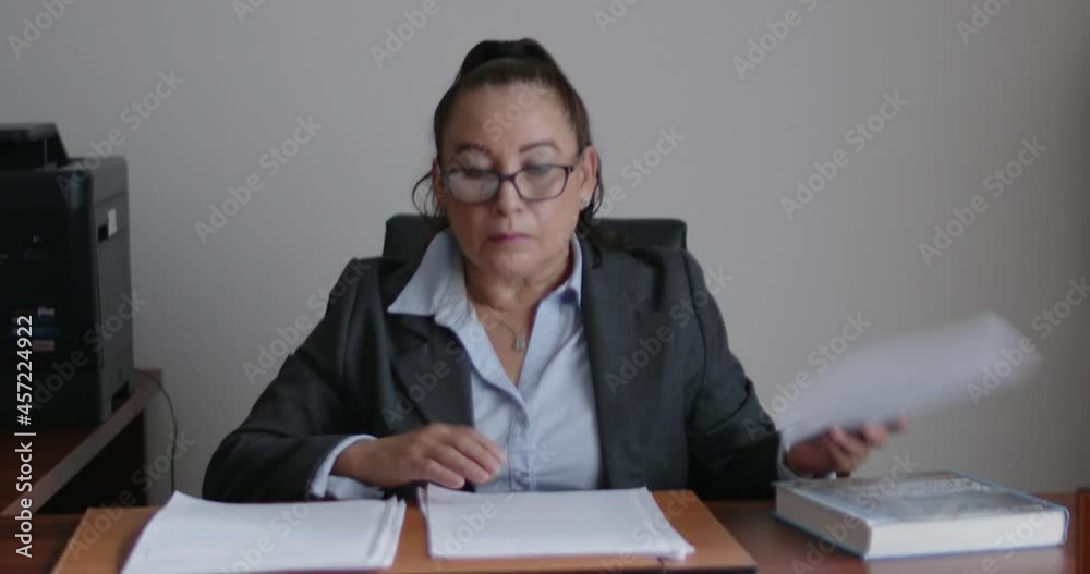 Mujer de negocios de la tercera edad revisando documentos en su oficina.