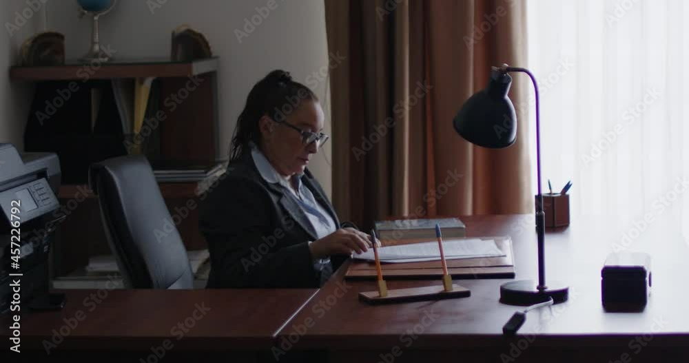 Mujer de negocios de la tercera edad revisando documentos en su oficina.