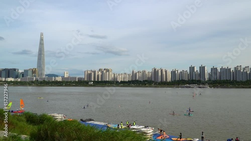 Lotte World Tower in the background with sailboarders and paddle boarders in Han river, Seoul South Korea