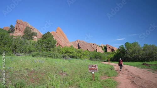 Female Backpacker Walking on Hiking Trail in Roxborough State Park, Colorado USA on Sunny Summer Day, Slow Motion Full Frame photo