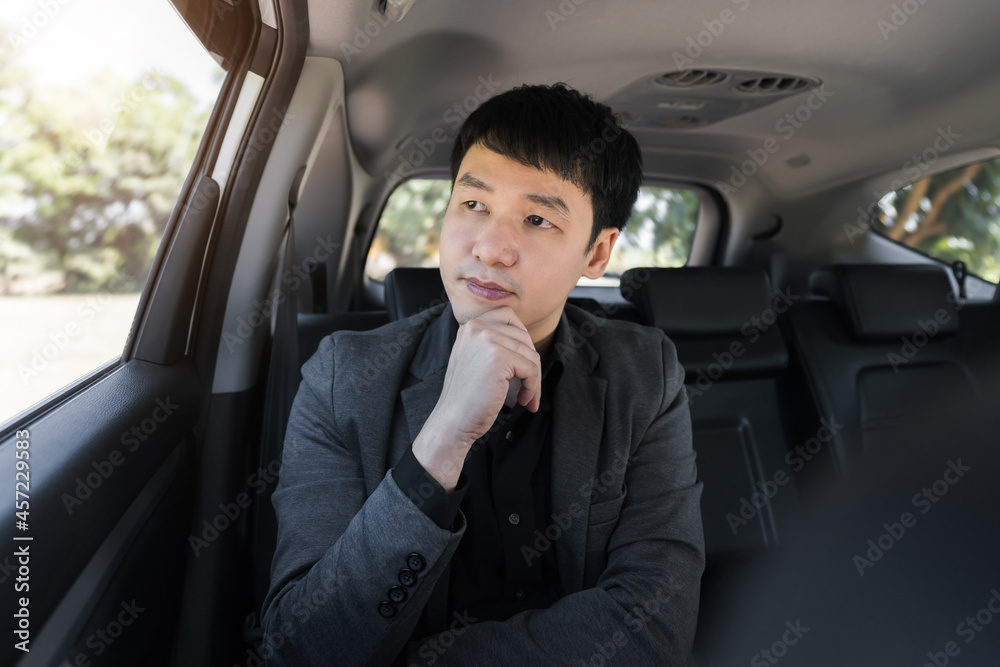 business man thinking while sitting in the back seat of car business man thinking while sitting in the back seat of car