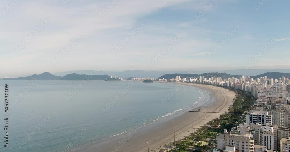 drone flying over buildings and shore. top shot of the sandy beach with city buildings on the shoreline. . slow side camera movement with mountains in background drone flying over buildings and shore. top shot of the sandy beach with city buildings on the shoreline. . slow side camera movement with mountains in background