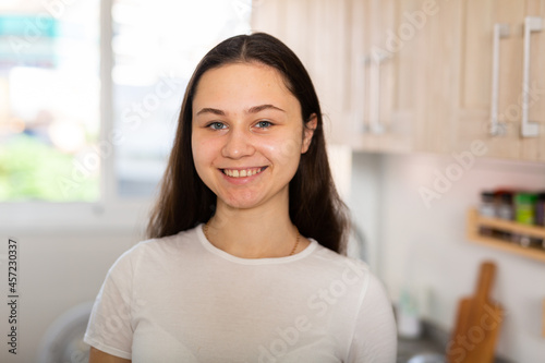 Portrait of cheerful caucasian woman standing at kitchen