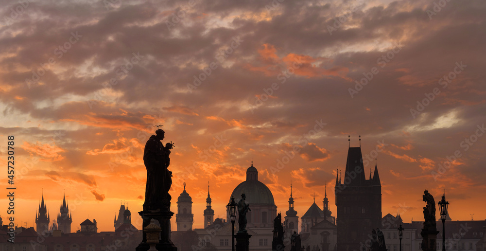Obraz premium Sunrise over the capital of the Czech Republic - Prague city with silhouettes of buildings and statues