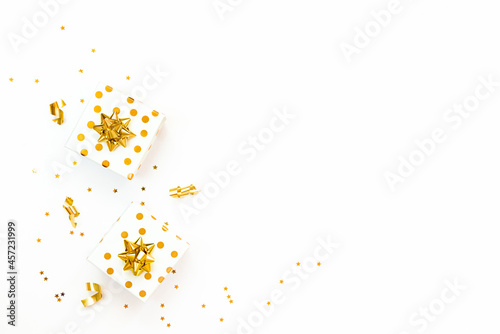 Obraz na płótnie Top view of golden dotted gift boxes and star shaped golden confetti on a white background. Copy space. w salonie