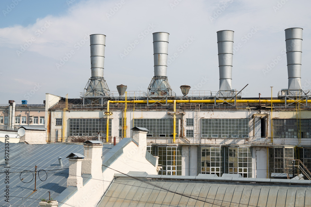 Obraz premium city ​​industrial pipes with buildings