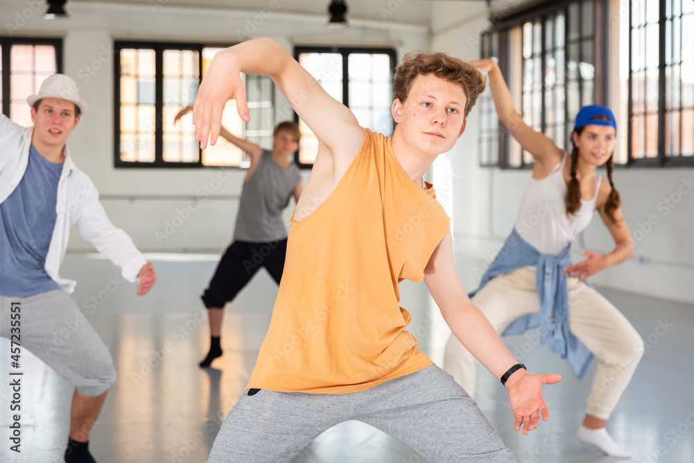 Obraz premium Team of young dancers training street dance moves and having fun