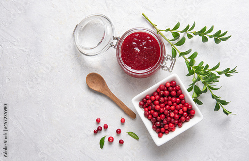 Foto Concept flat lay with homemade lingonberry jam and forest cowberry in bowl on white background