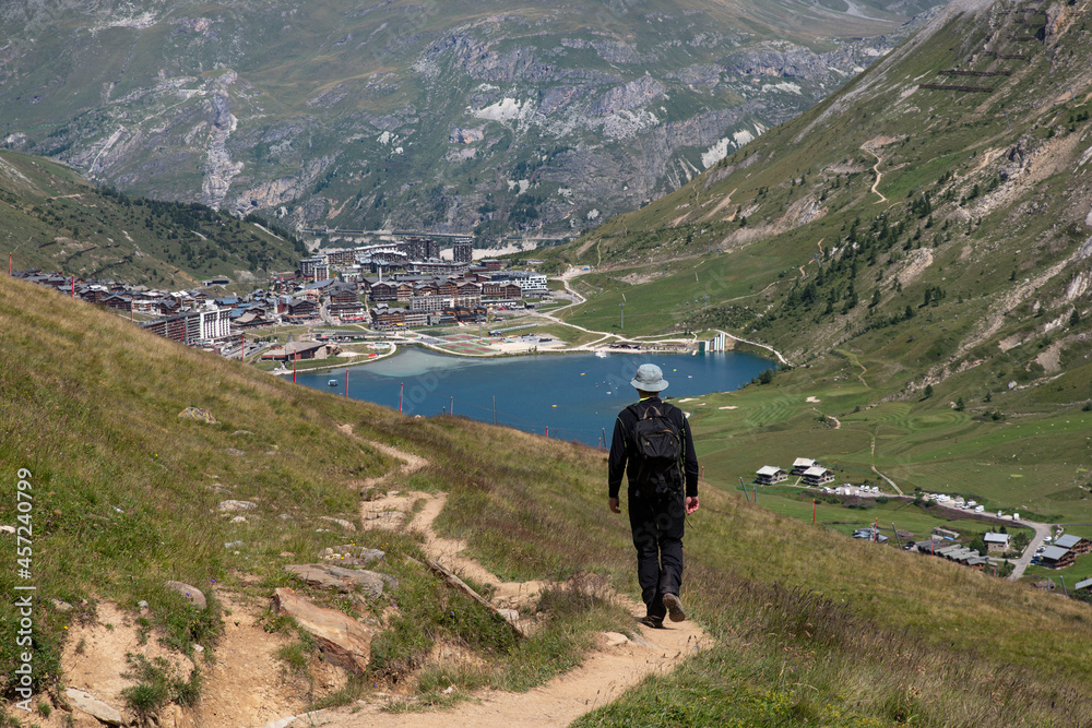 A summer hiker looking at the resort of Tignes in France