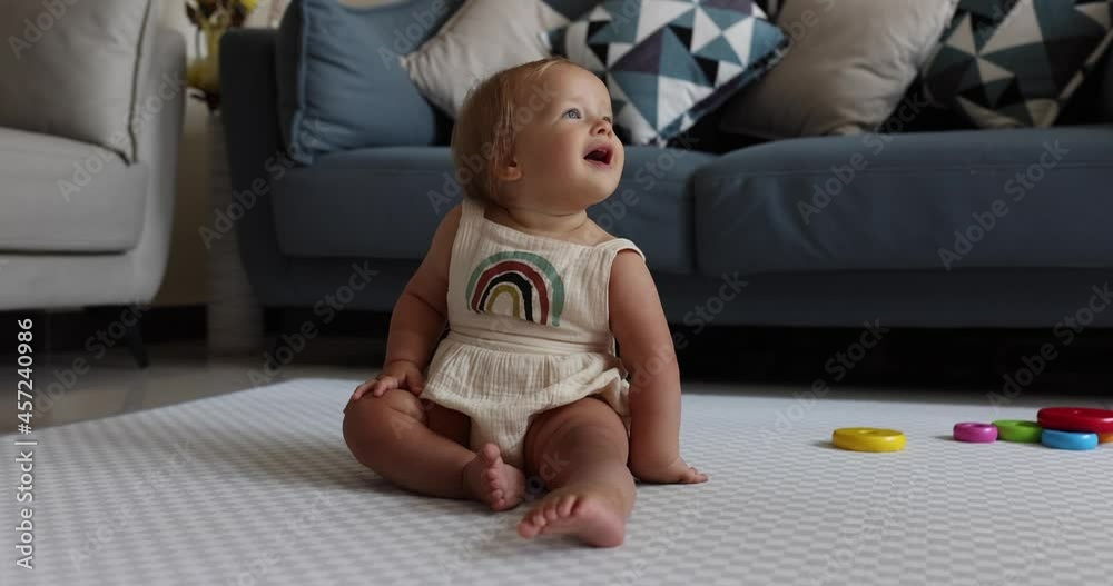 Authentic close up Cute Caucasian Baby Girl 1 year old Playing on floor in living room at home. Slow Motion. Authentic close up Cute Caucasian Baby Girl 1 year old Playing on floor in living room at home. Slow Motion.