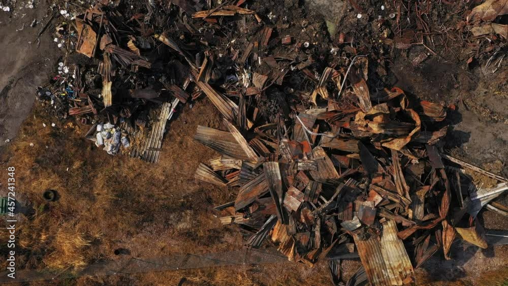 Aerial view over metal structure remains, rubble, wood and debris strewn - overhead, drone shot Aerial view over metal structure remains, rubble, wood and debris strewn - overhead, drone shot