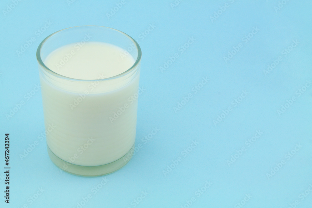 Glass of milk on blue background with room for text