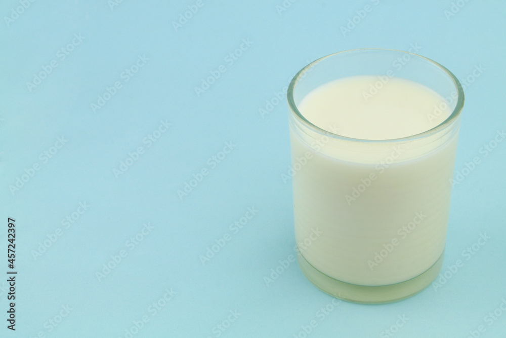 Glass of milk on blue background with room for text Glass of milk on blue background with room for text