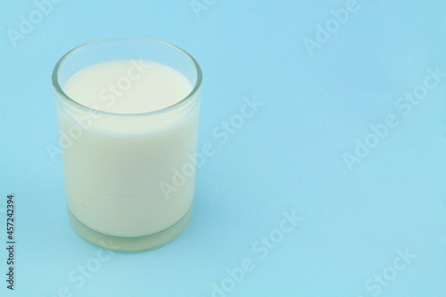 Glass of milk on blue background with room for text