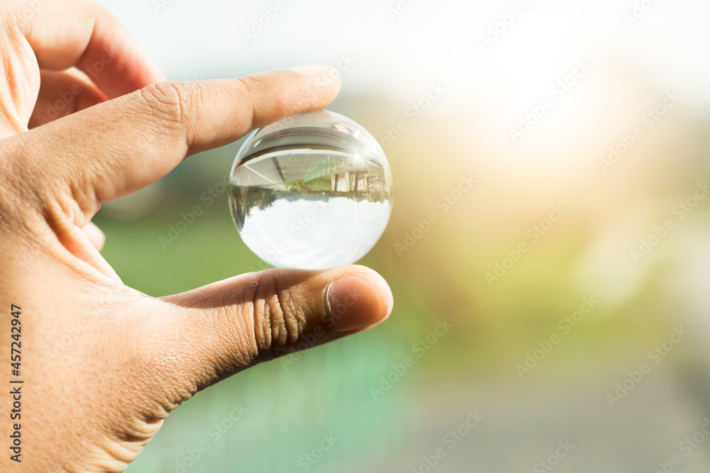 close-up hand holding bright crystal ball isolated natural background