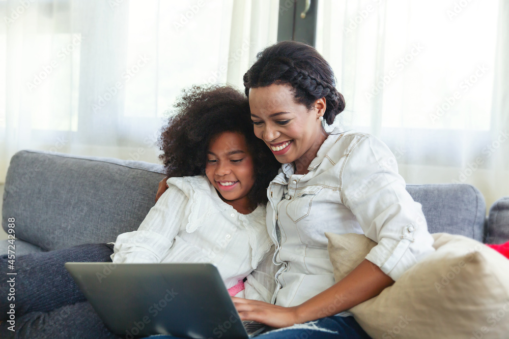 Mother And Daughter spending time together on sofa and using Digital Tablet at home Mother And Daughter spending time together on sofa and using Digital Tablet at home