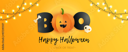 Happy Halloween horizontal card with inscription boo, skull , bone and pumpkin in paper cut style. Funny paper pumpkin with black letters on yellow background. 