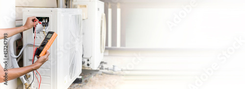 Cuadro en lienzo Air conditioner repairman using electricity meter to check air conditioner opera