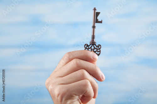 Male hand holding old key. Business. Success