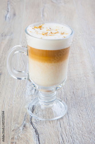 latte cappuccino in a transparent glass on a jar background

