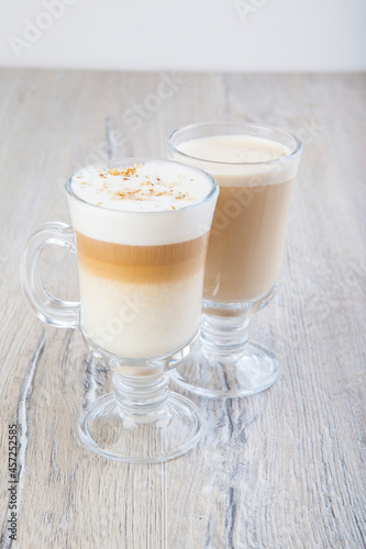 latte cappuccino in a transparent glass on a jar background
