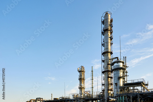Oil refinery chemical plant wide view with copyspace over blue evening sky with clouds background. Methanol production distillation refinery columns industrial background with copyspace.