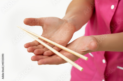 Cosmetologist in pink medical uniform holds bamboo massage sticks in his hands . Small business. SPA salon. Beauty industry. Anti-aging procedures. Massage treatments.